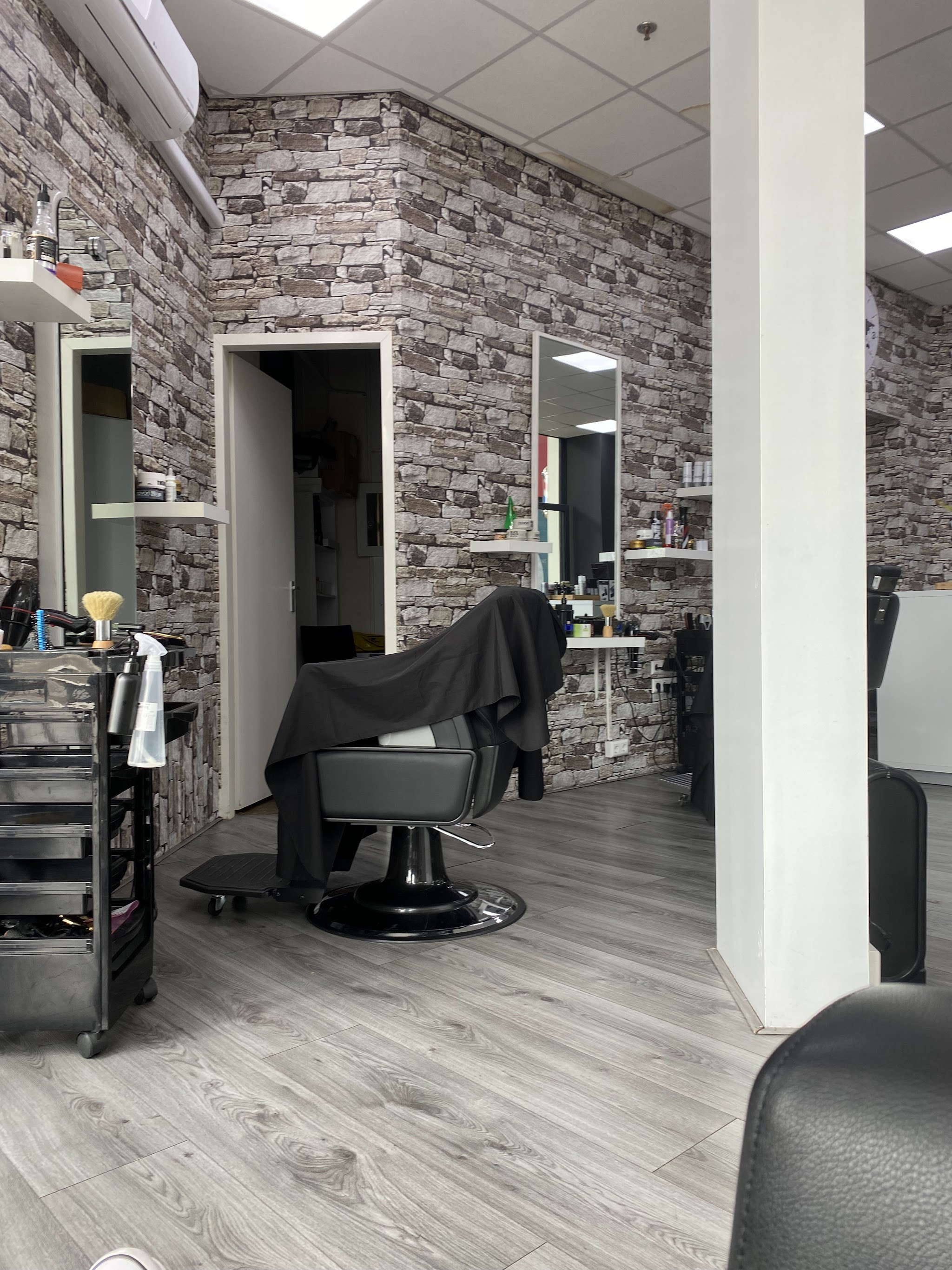 Stylingstoel en spiegels in het lichte interieur met stenen wand